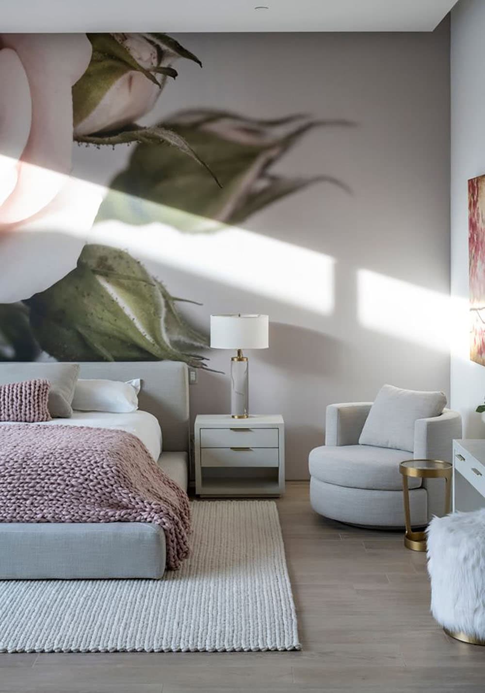 A bedroom with a large wall mural and a bed.