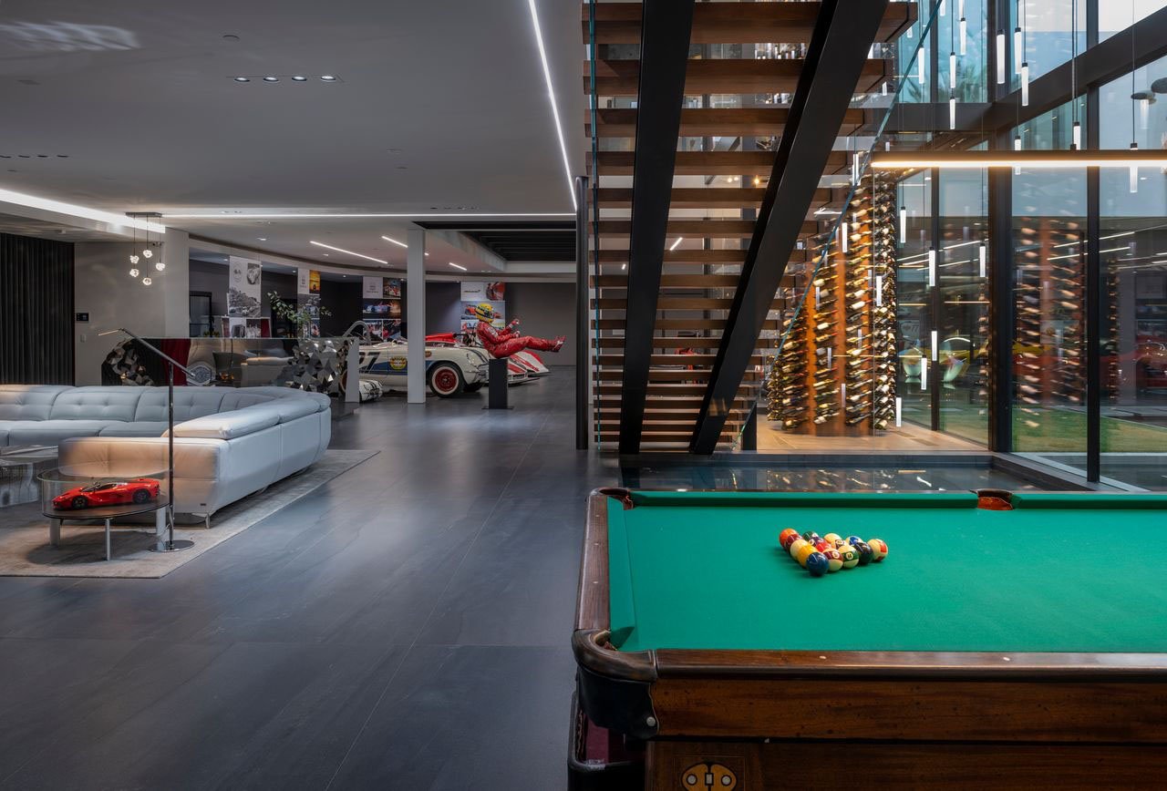 A pool table in a modern home with a glass wall.