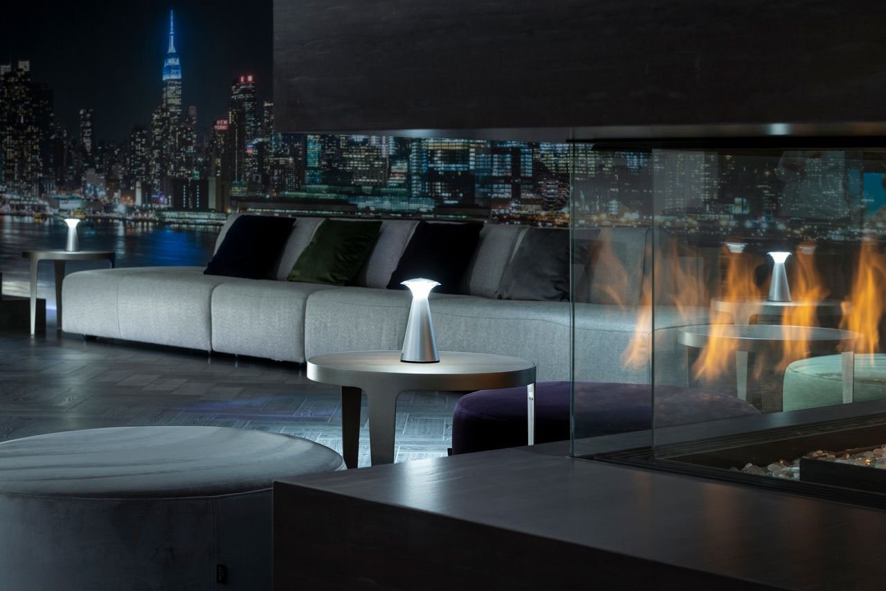 A modern fireplace with a cityscape wall at night.