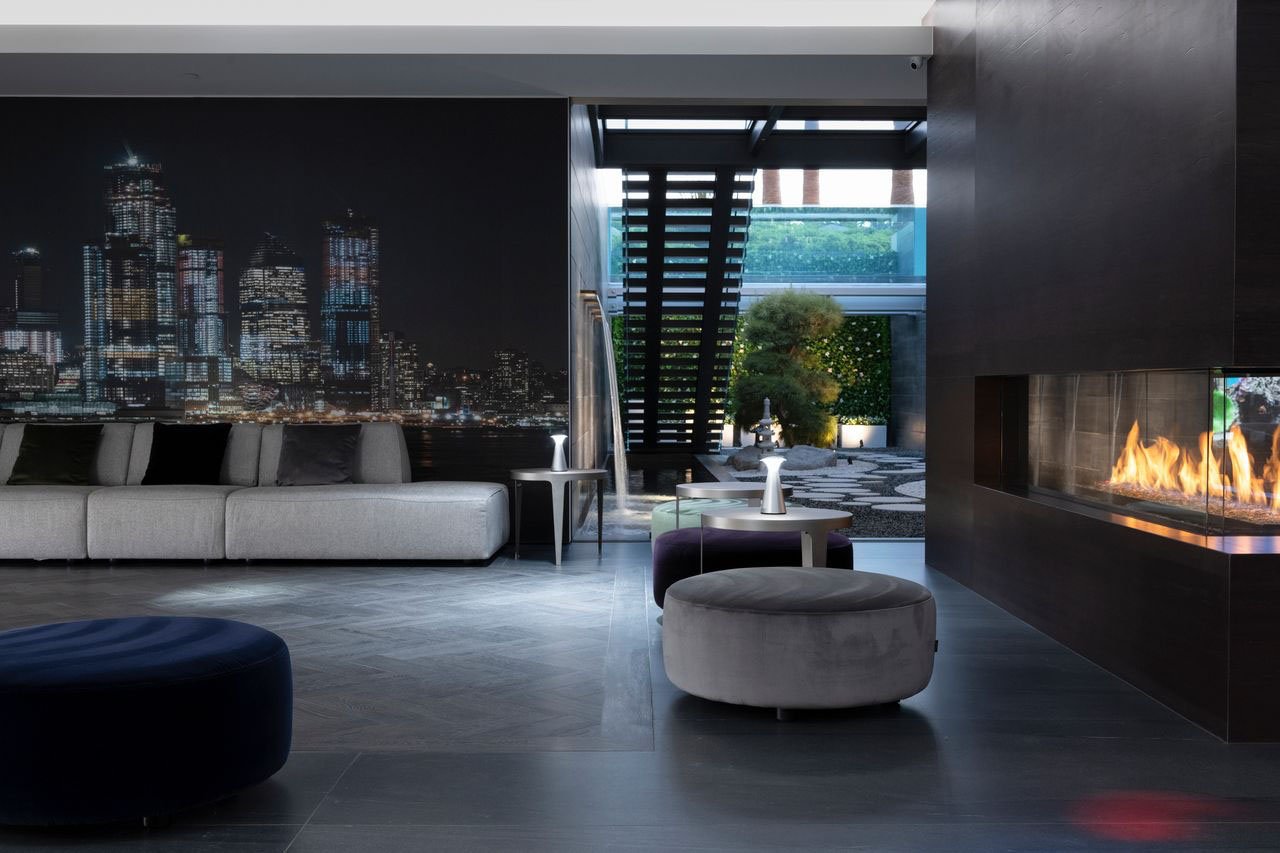 Modern living room with fireplace and cityscape wall.