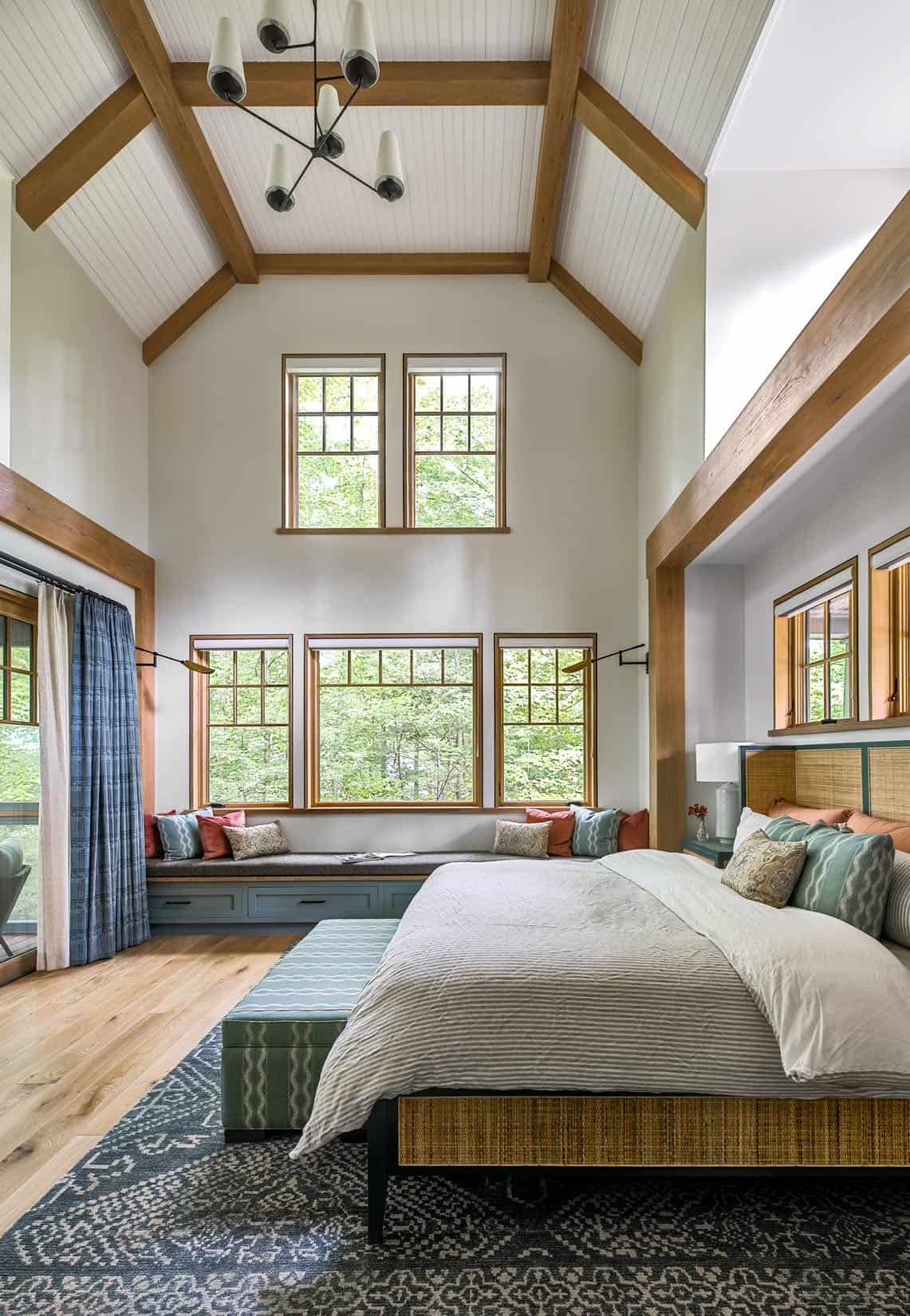 rustic bedroom with two-story ceiling and windows