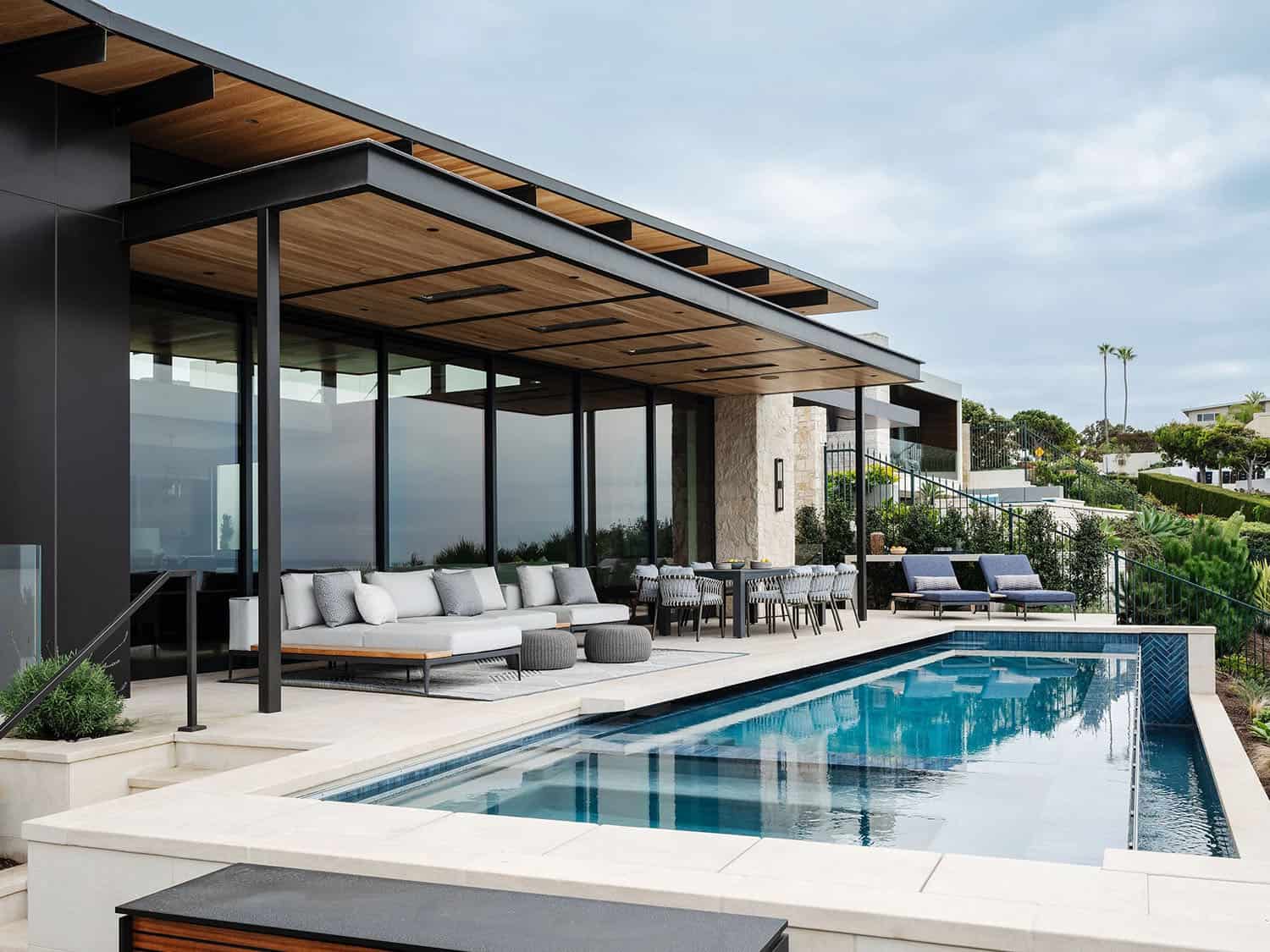 organic modern home exterior with a covered patio and a pool