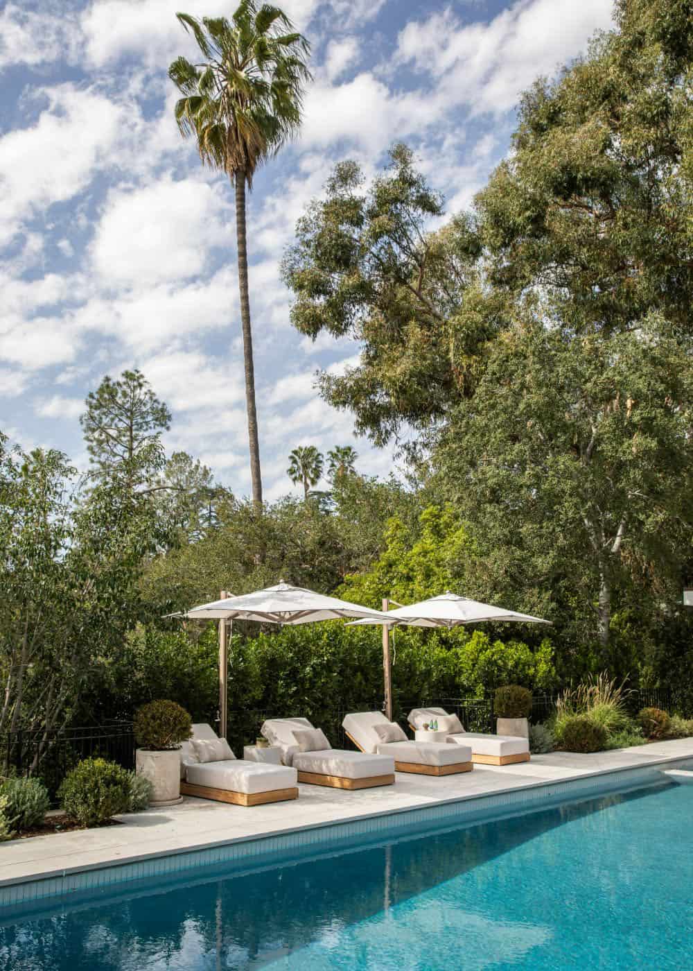 southern inspired home exterior patio with chaise lounges and umbrellas