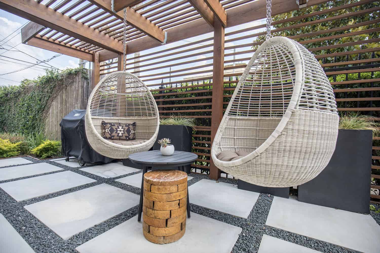 small backyard patio with a pergola and hanging chairs