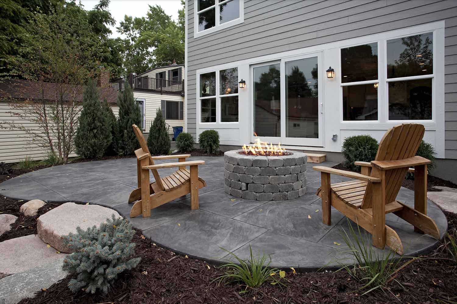traditional stamped and stained concrete patio with a fire pit and chairs