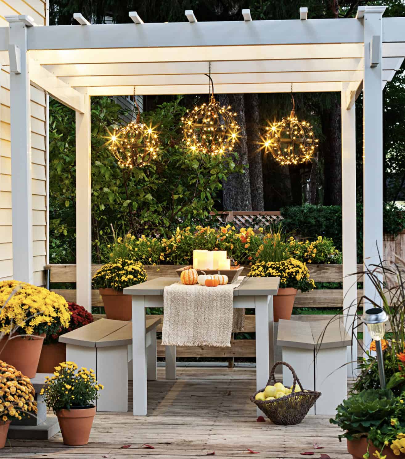 backyard patio with a pergola and outdoor dining table with hanging lights