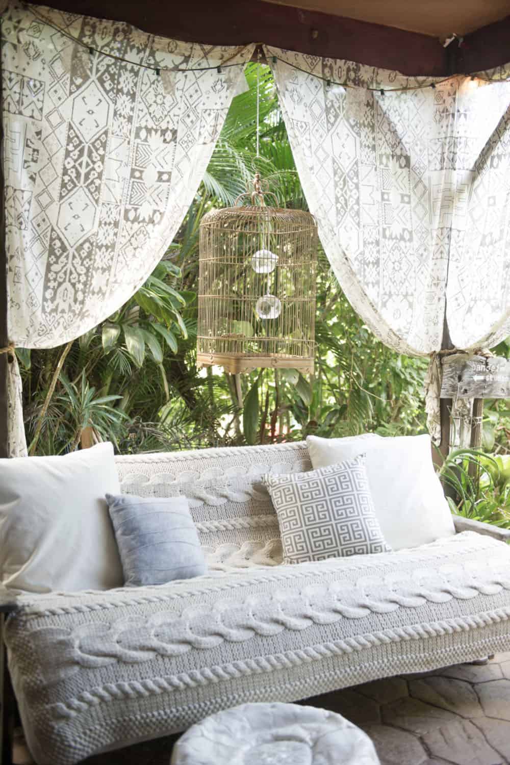boho chic covered patio with a lounge chair and curtains