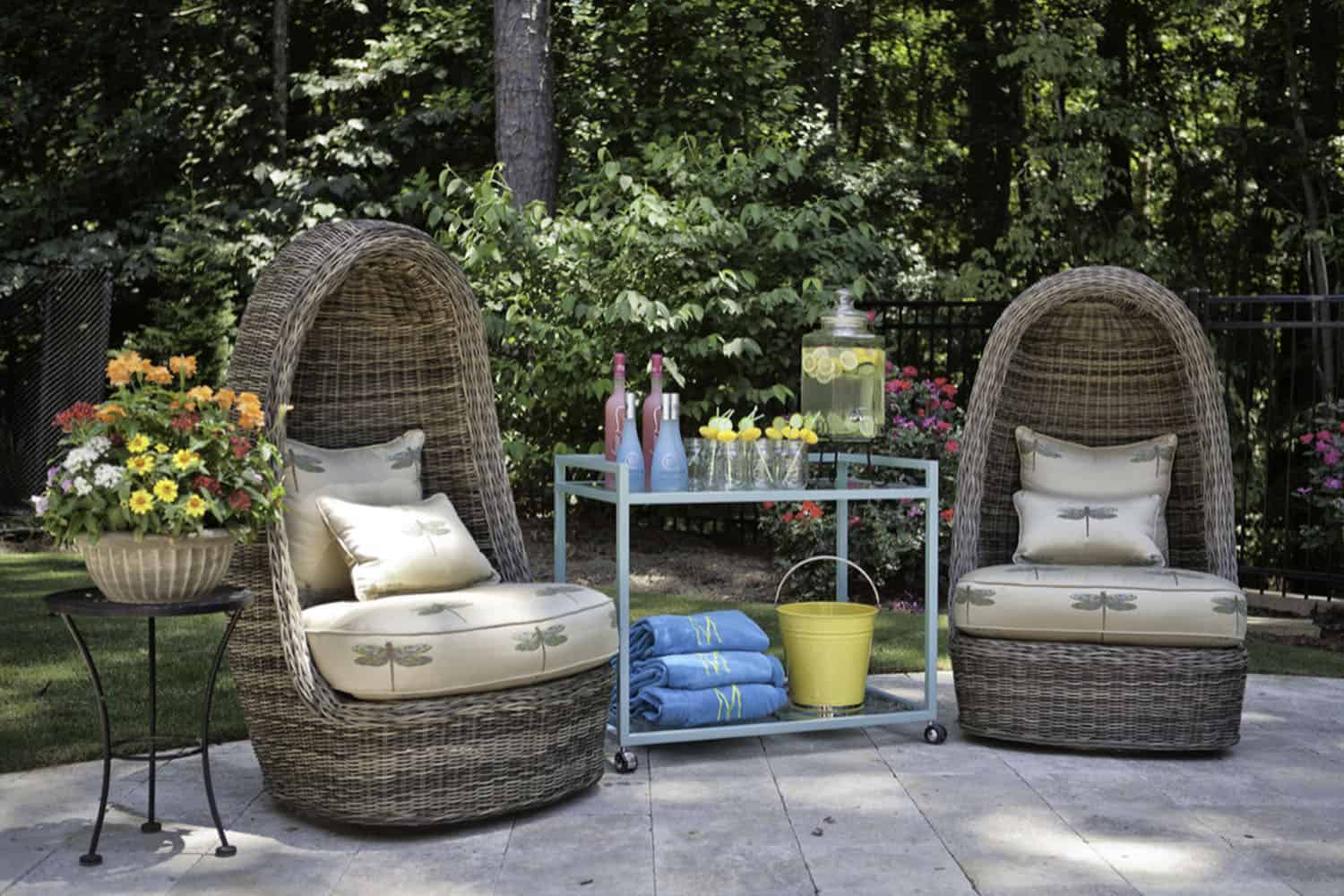 beach style patio with egg chairs and a bar cart
