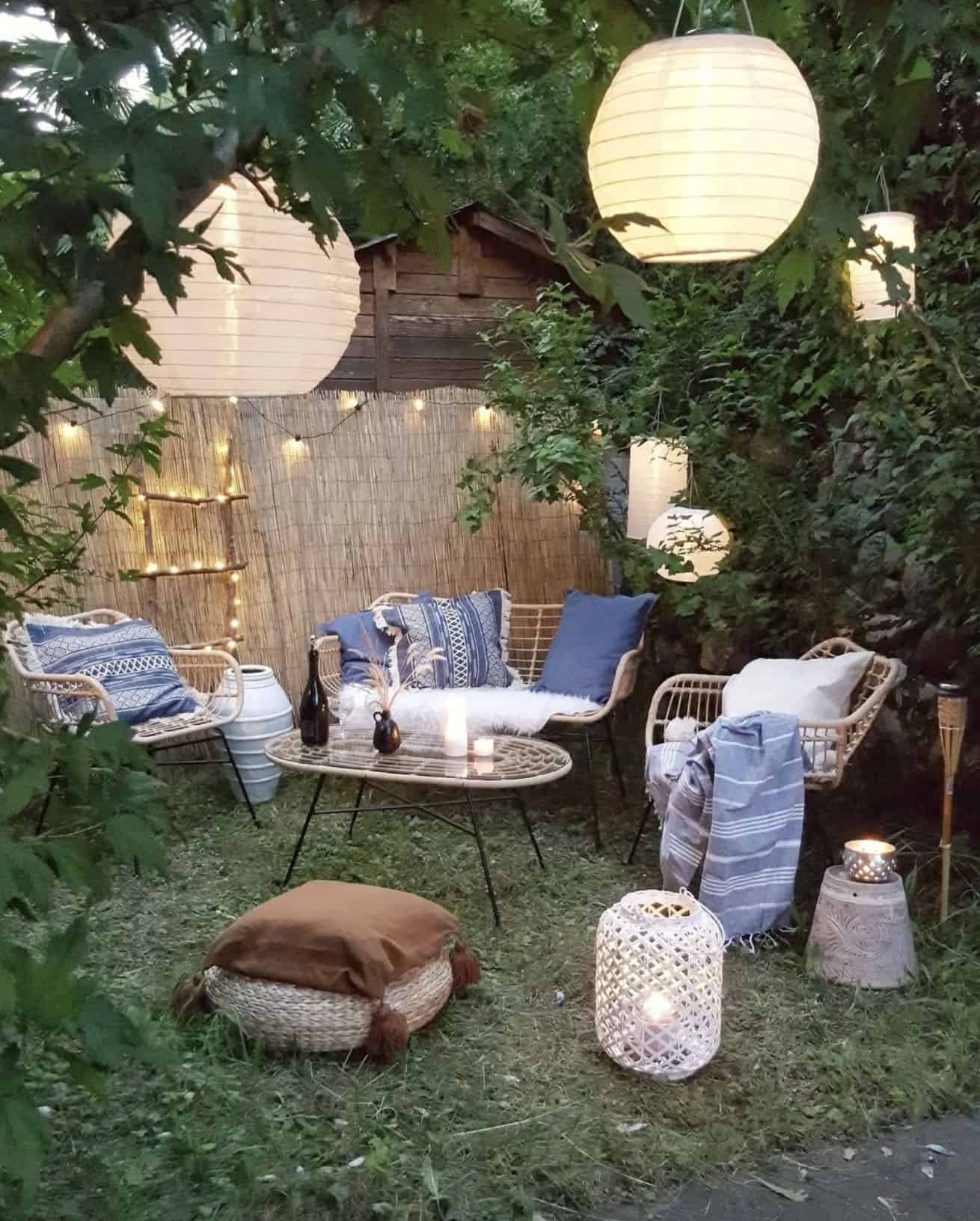 small backyard patio with hanging lanterns and string lights
