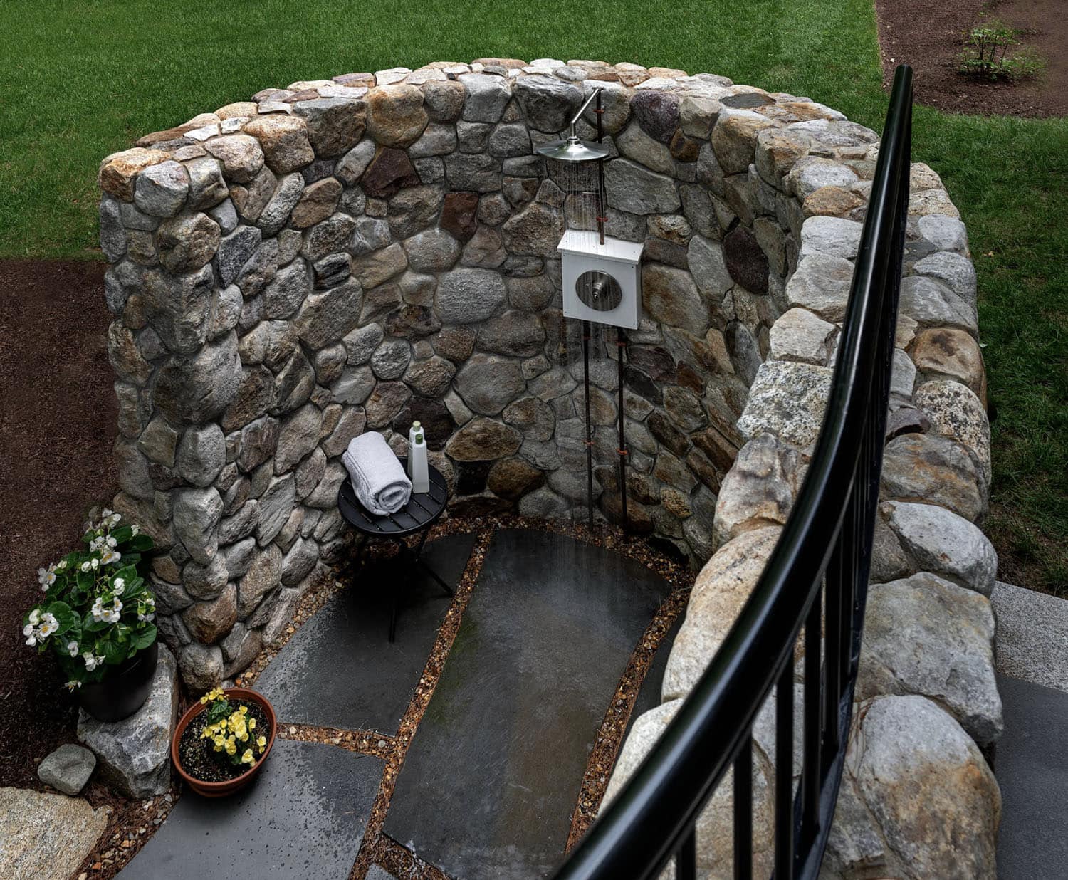 craftsman style lake house outdoor shower with a stone privacy wall