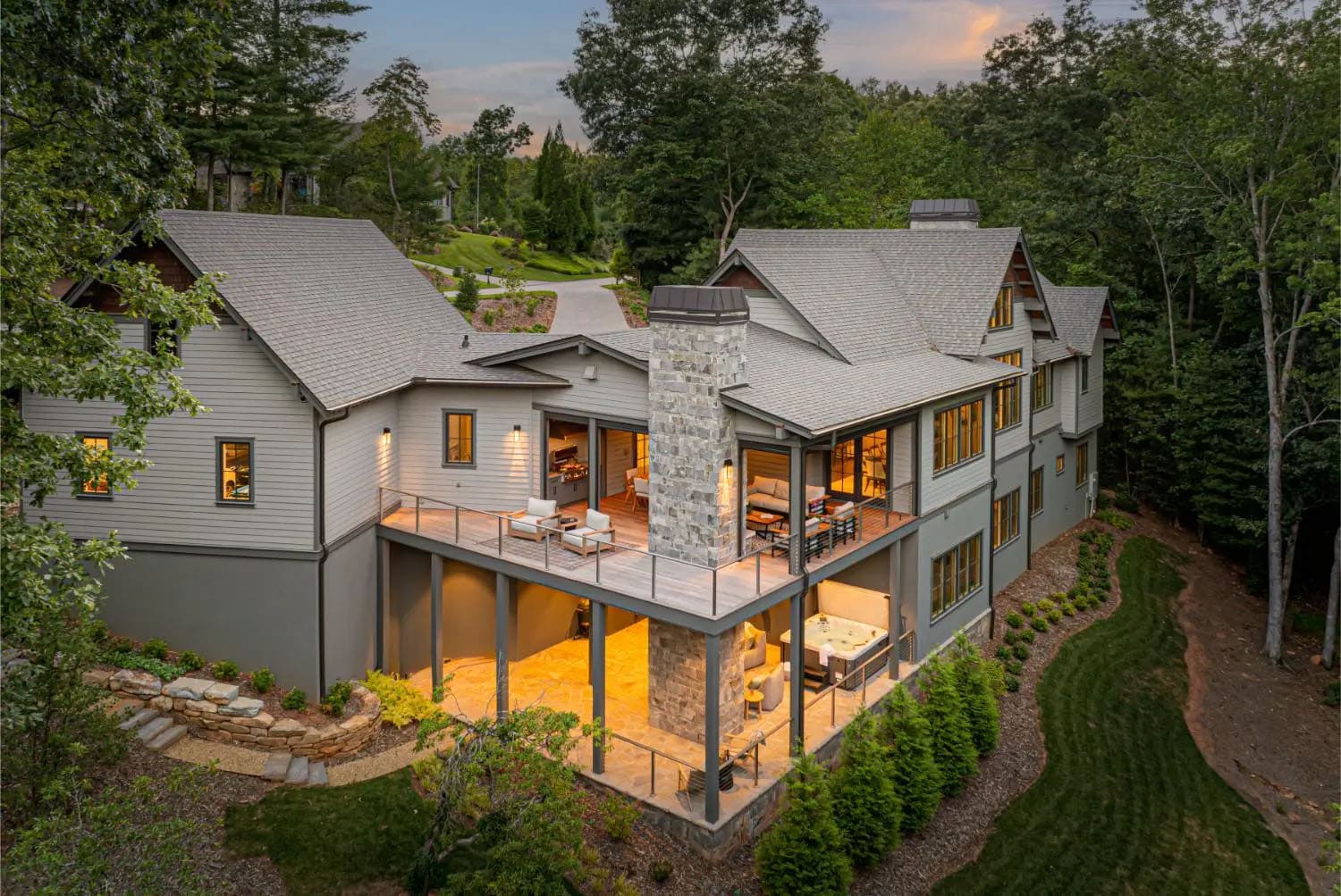 transitional style mountain home exterior backyard view at dusk