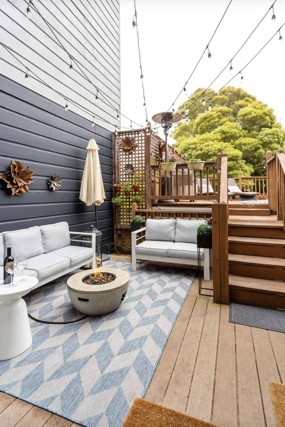 multi-level backyard deck with outdoor furniture and a fire pit