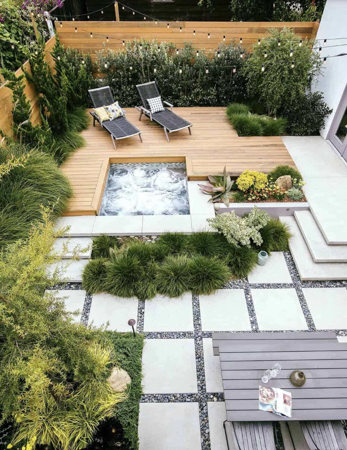 backyard deck with a hot tub, chaise lounges and string lights