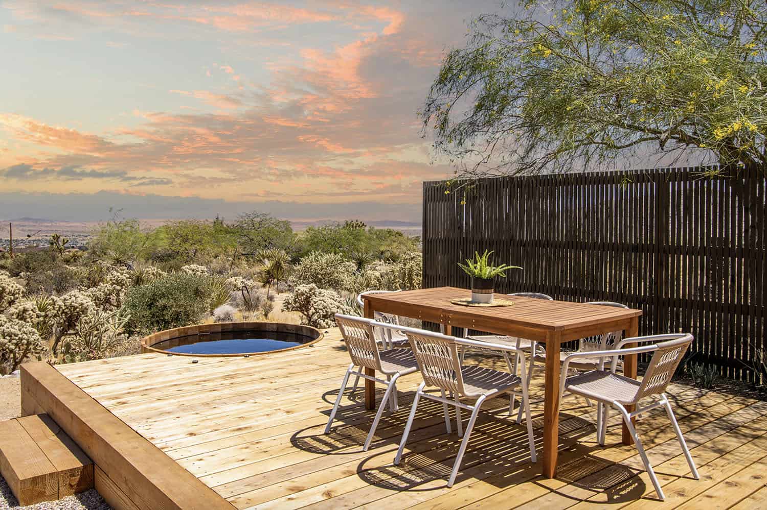 modern raised red oak deck with a dining table and chairs and a cedar tub
