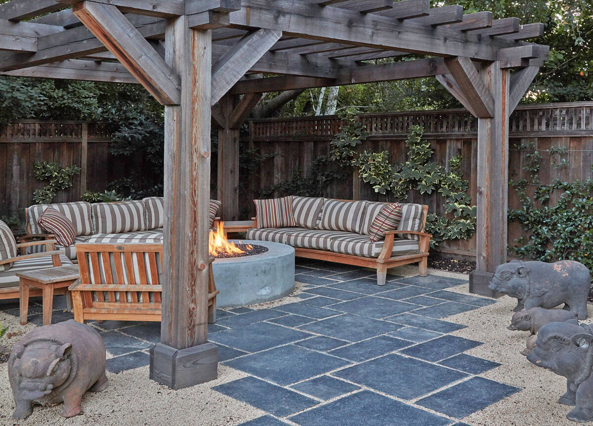 arbored lounge area with a fire pit and clay pigs