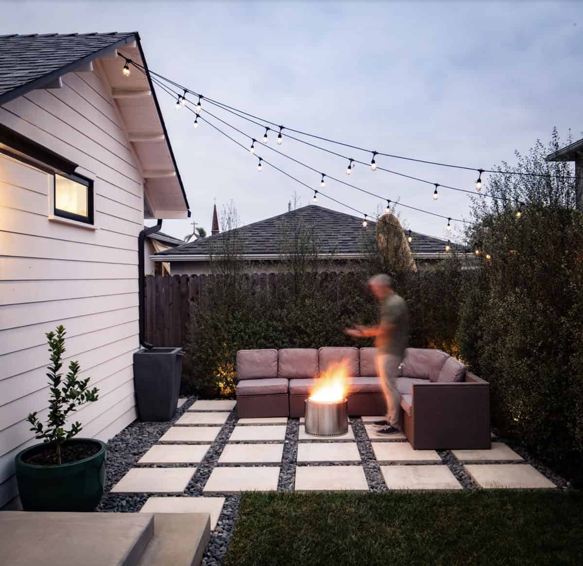 farmhouse style backyard patio with a fire pit and string lights