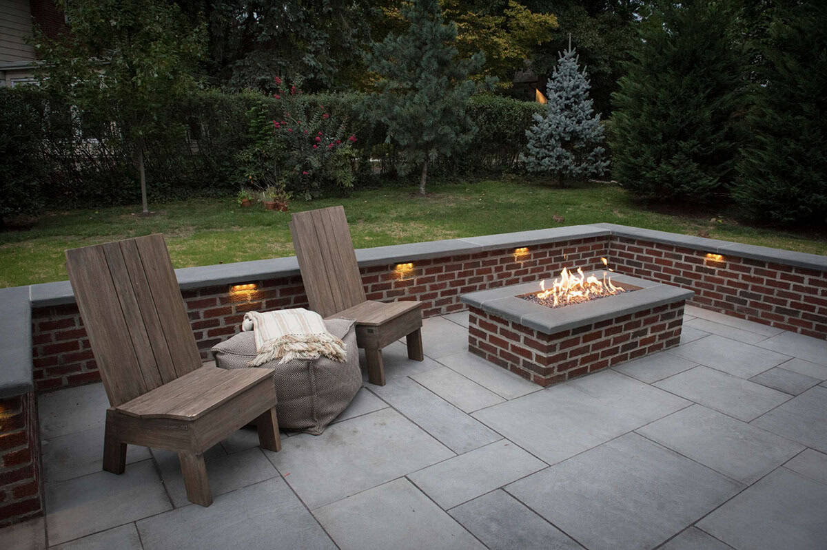 Patio seating area with a gas firepit and seatwall
