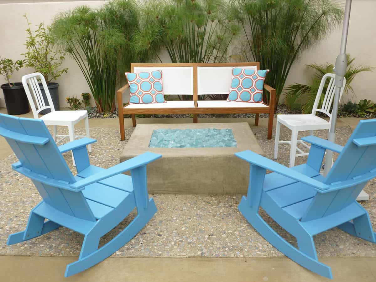 Poured in place concrete firepit with blue adirondack rocking chairs