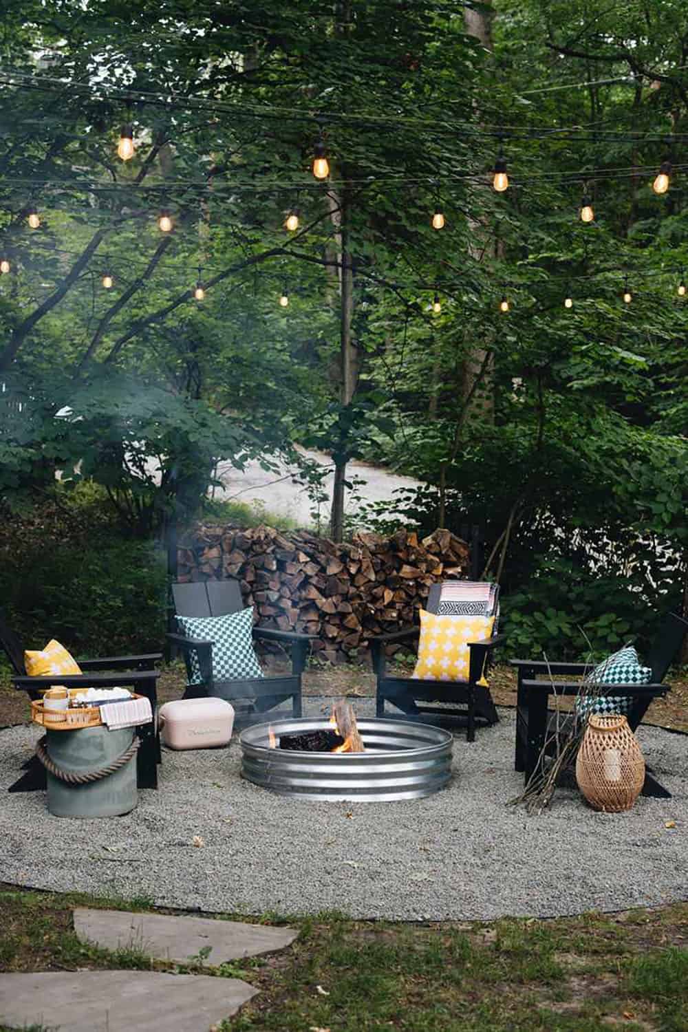 metal fire ring with a gravel patio. and string lights