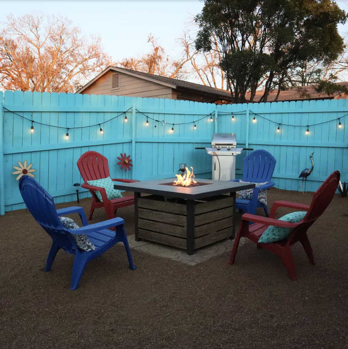 patio with a turquoise privacy fence, decomposed granite and fire pit