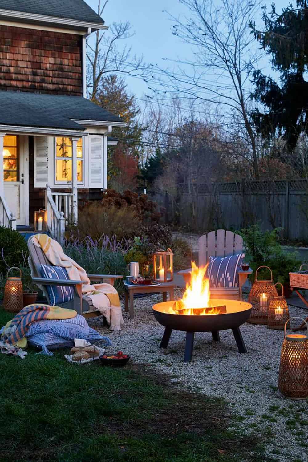backyard fire pit with lanterns and adirondack chairs