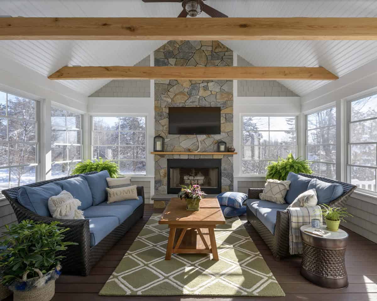 transitional style sunroom with a stone fireplace