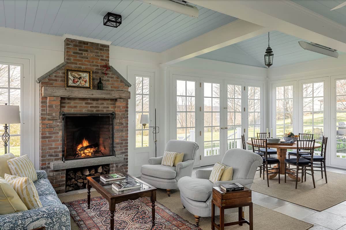 three-season farmhouse style sunroom with a fireplace