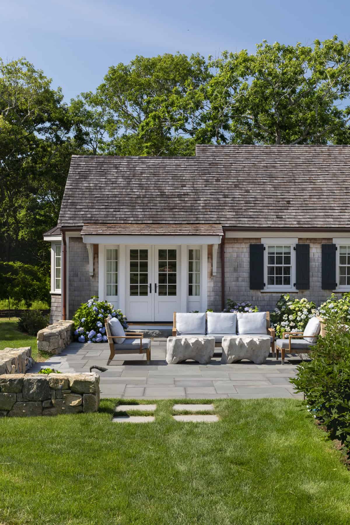 cape-style home exterior with a patio and outdoor furniture