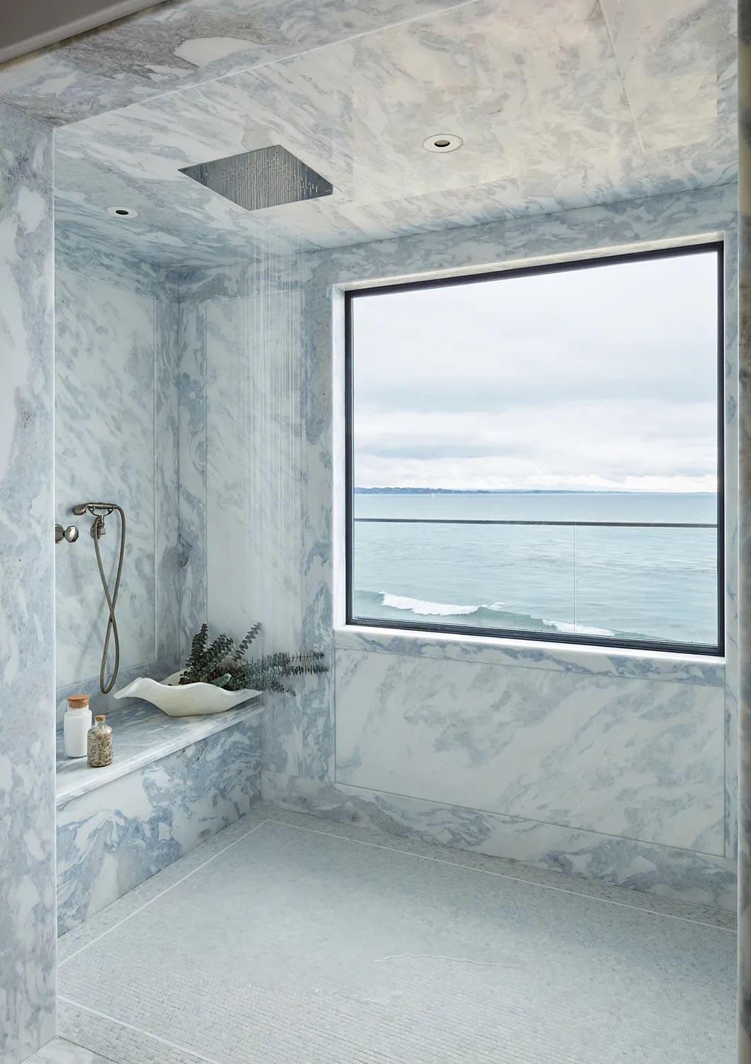 coastal style bathroom shower with a large window and Pacific ocean view
