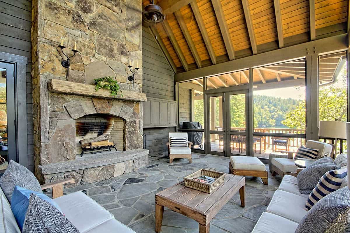 farmhouse style covered porch with outdoor furniture and a fireplace