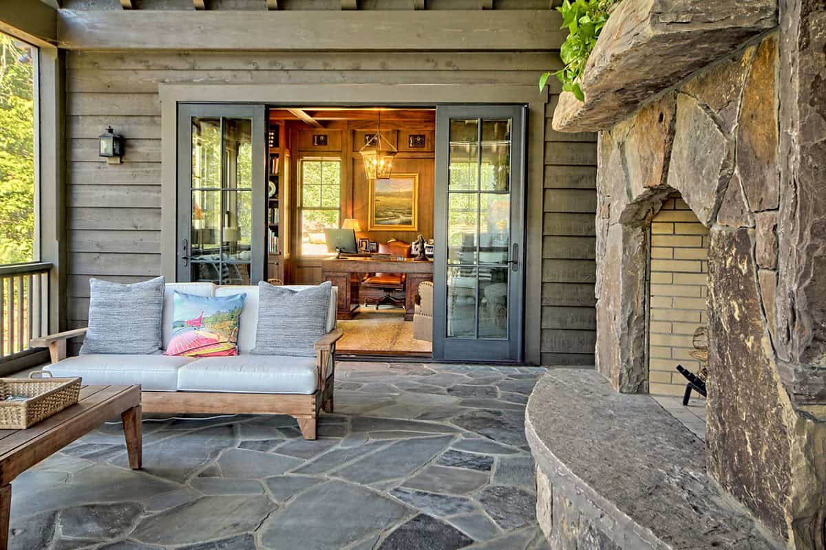 farmhouse style covered porch with outdoor furniture and a fireplace