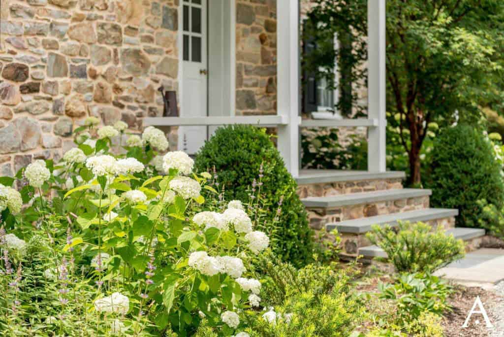 historic farmhouse home exterior steps with a garden