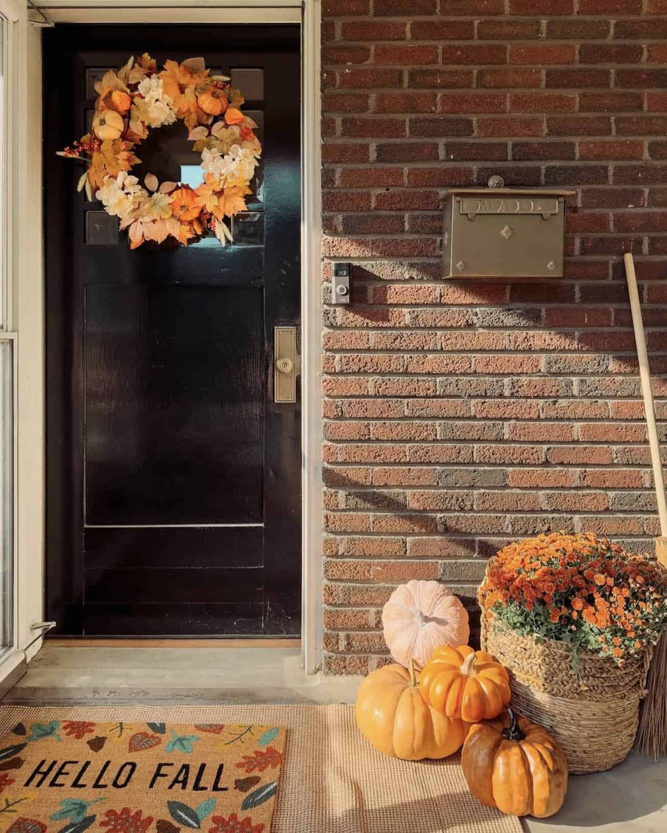 fall decorated front porch with a wreath and doormat