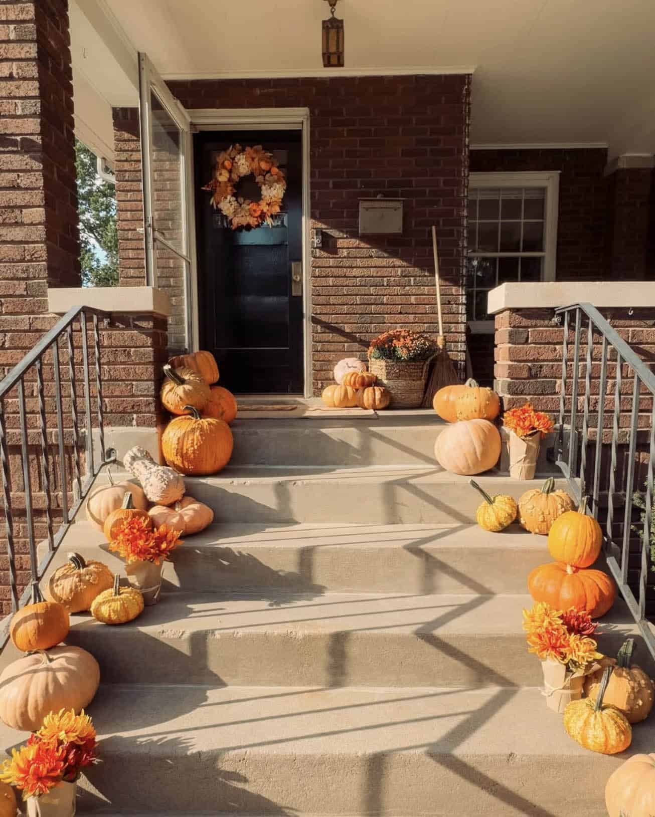 fall decorated front porch with pumpkins and a wreath