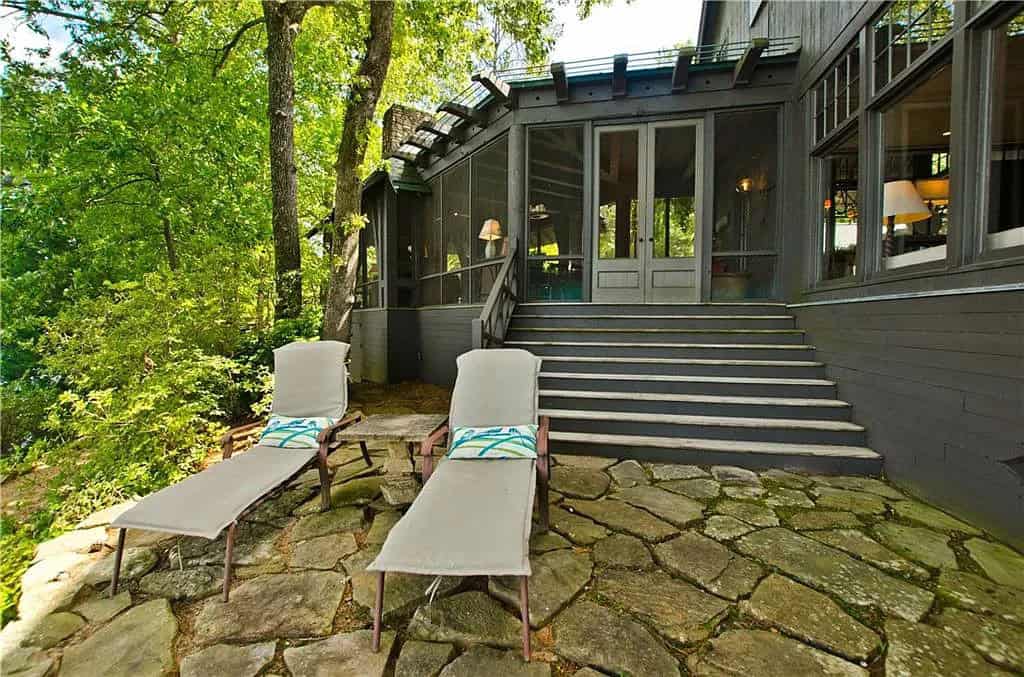 rustic lake house exterior landscaping with a patio and chaise lounges