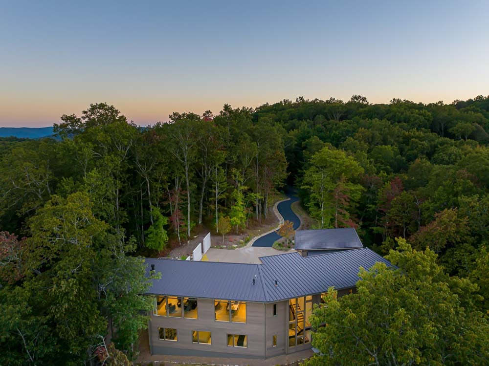modern mountain home exterior aerial view at dusk