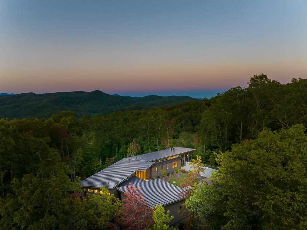 modern mountain home exterior aerial view at dusk