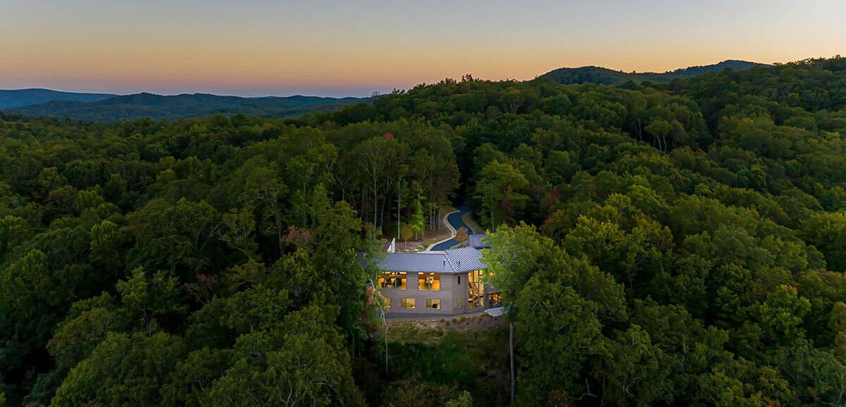 modern mountain home exterior aerial view at dusk