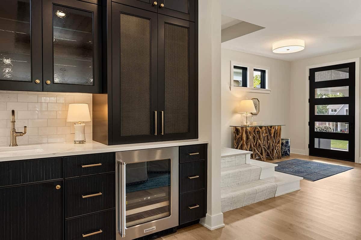 modern tudor home entry with a wet bar and staircase