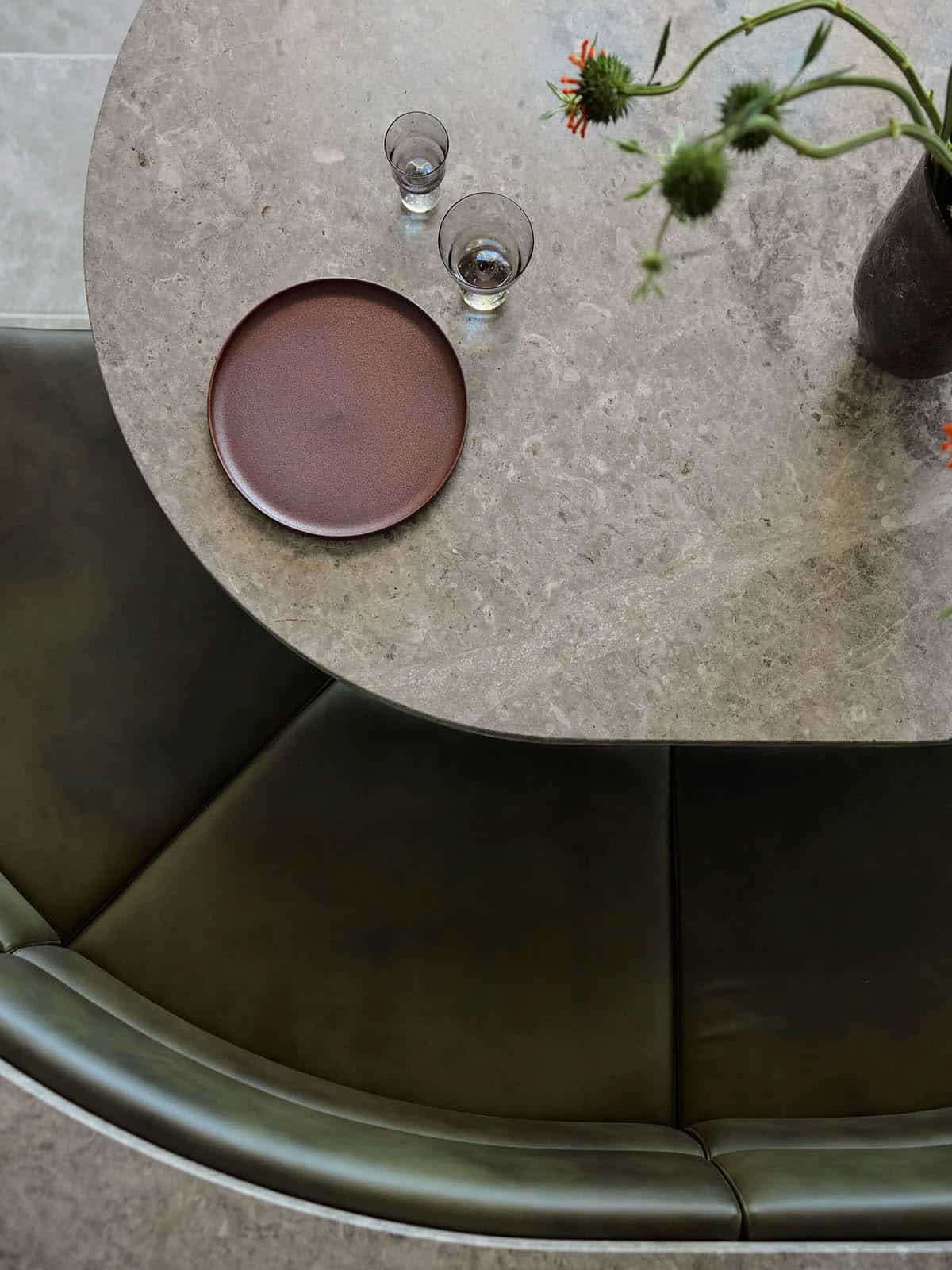 A table with a vase of flowers and a plate.