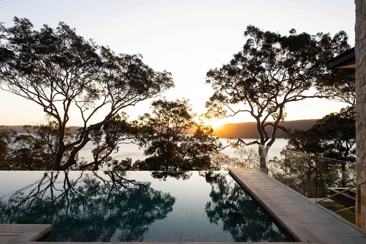 A swimming pool overlooking the water and trees.