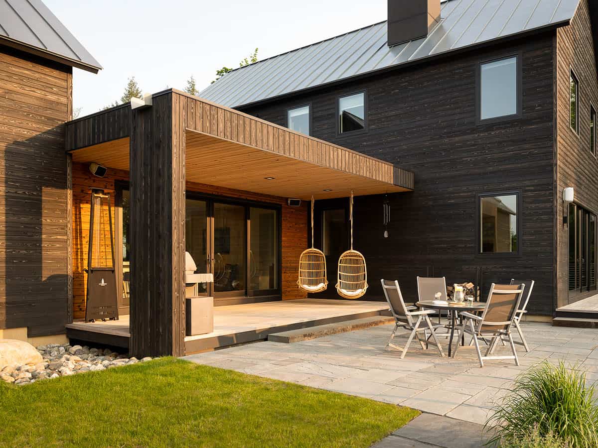 modern home exterior covered porch with hanging chairs