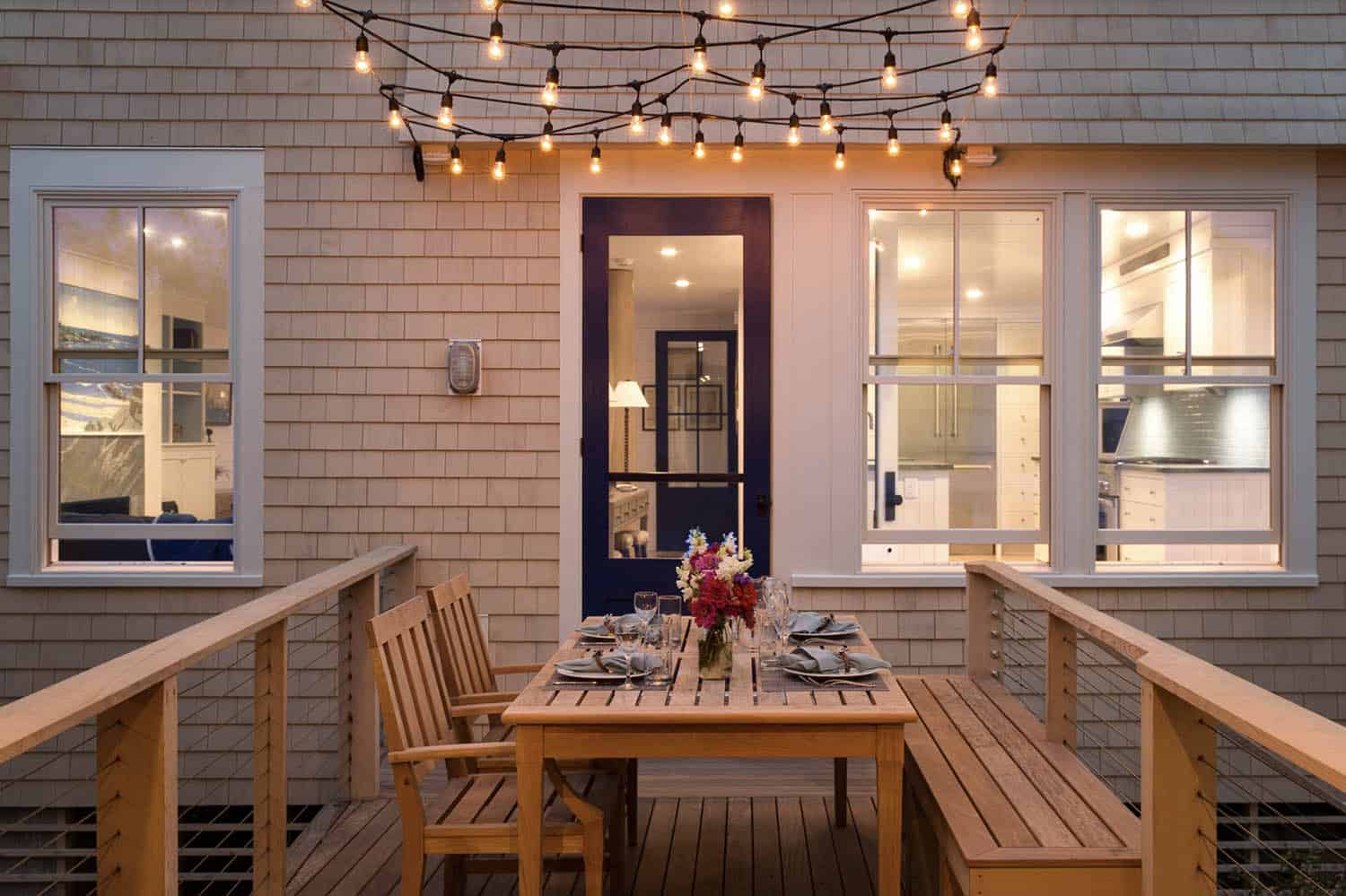 small deck with outdoor dining and string lights