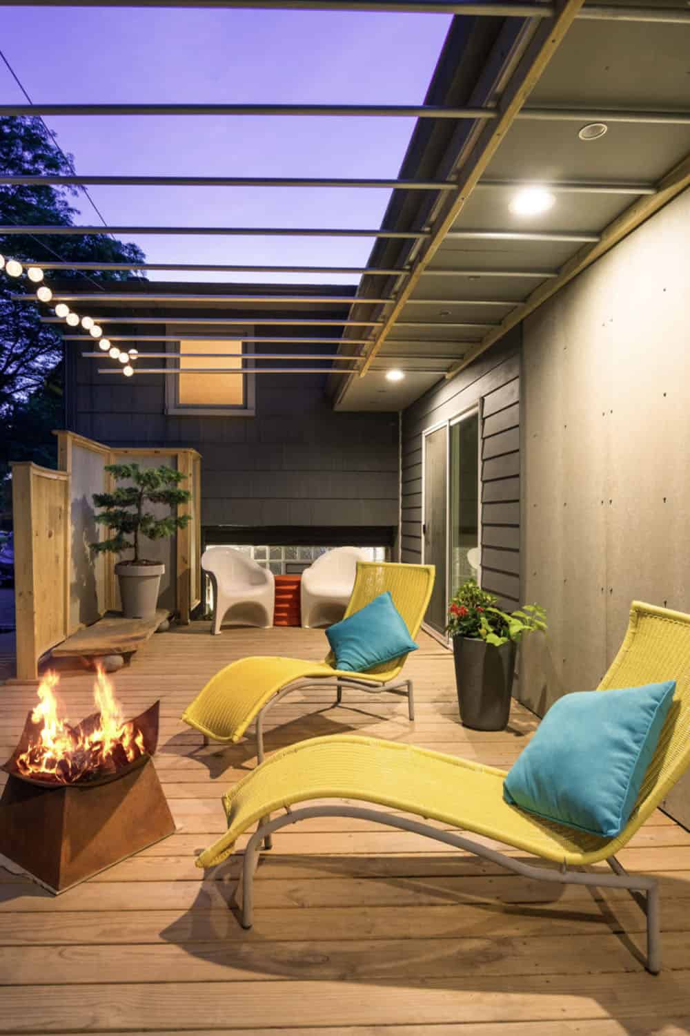 midcentury modern style deck with lounge chairs and a fire pit