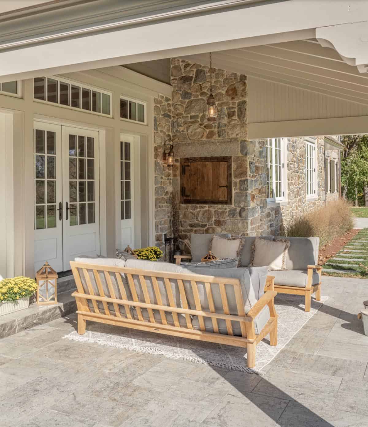 stone farmhouse style house exterior front porch with outdoor furniture