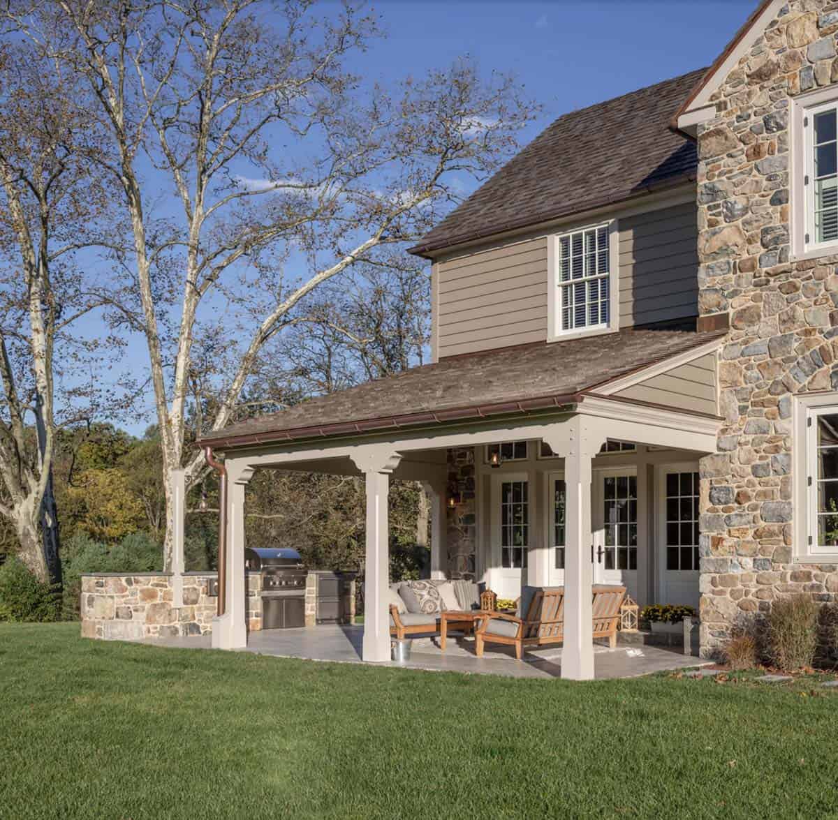 stone farmhouse style house exterior front porch with outdoor furniture