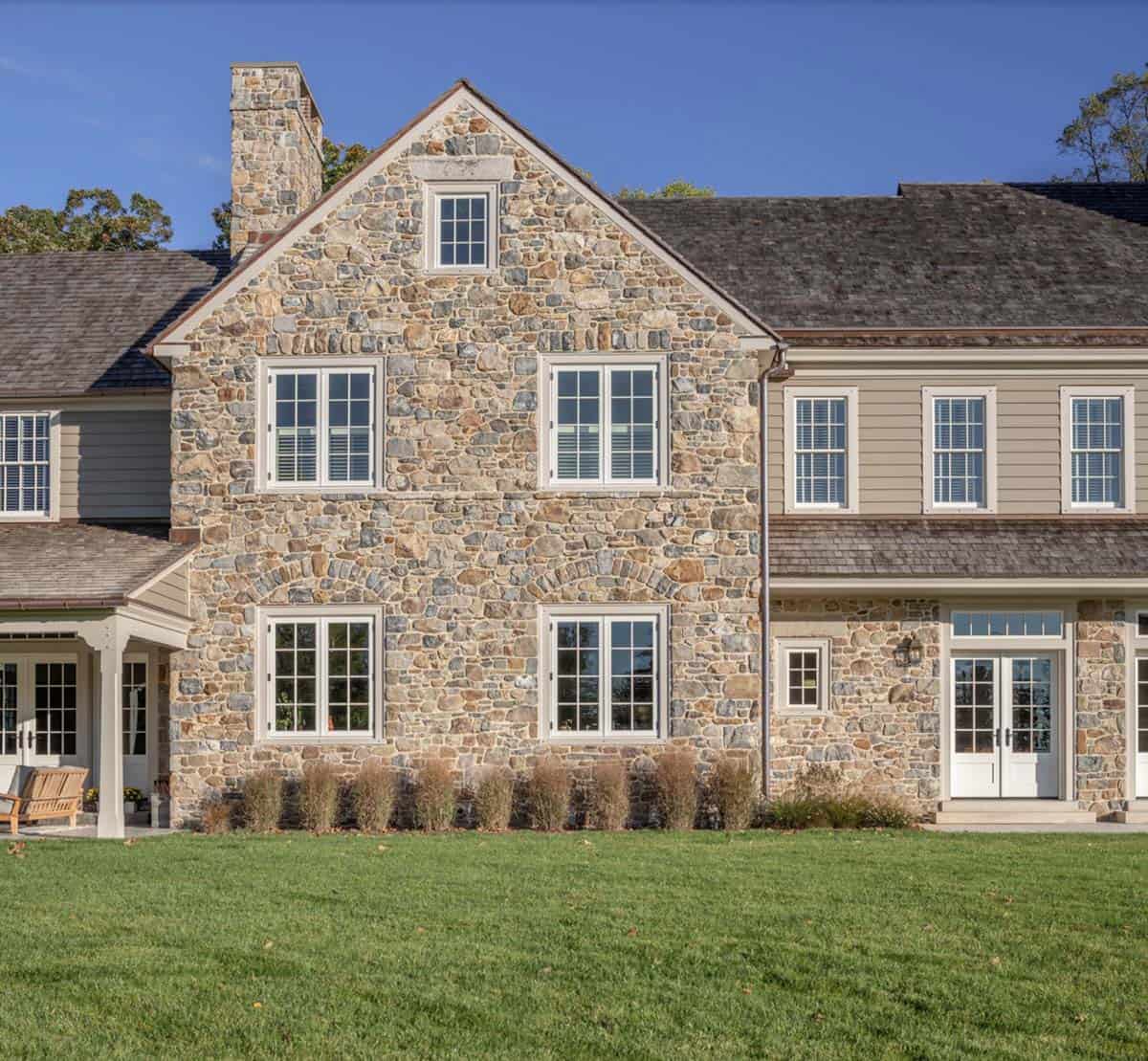 stone farmhouse style house exterior backyard view