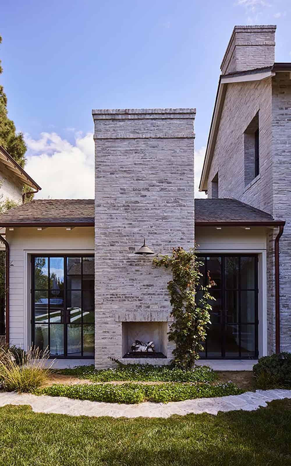 transitiional style home exterior with an outdoor fireplace