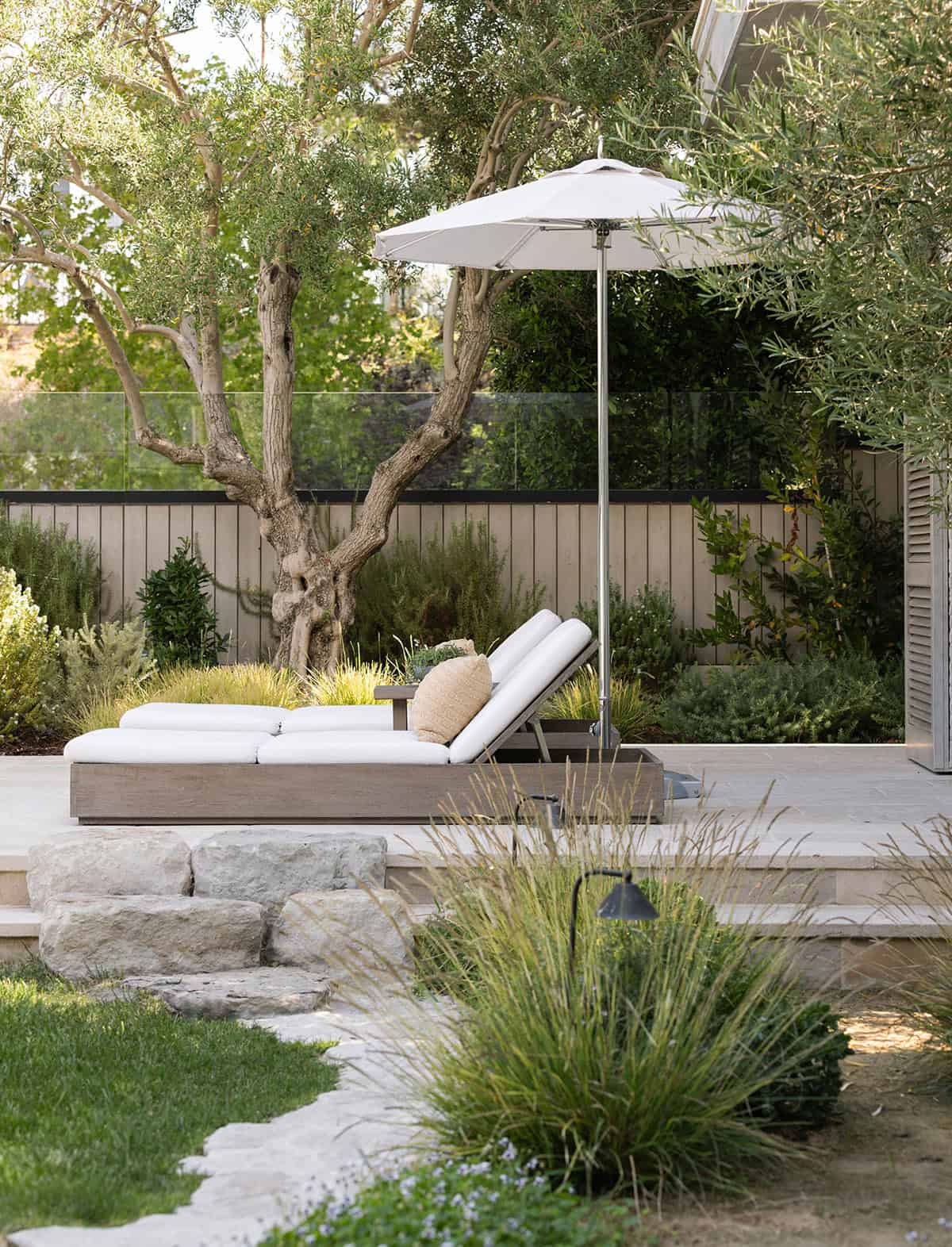 transitiional style home landscaping with a patio and chaise lounges
