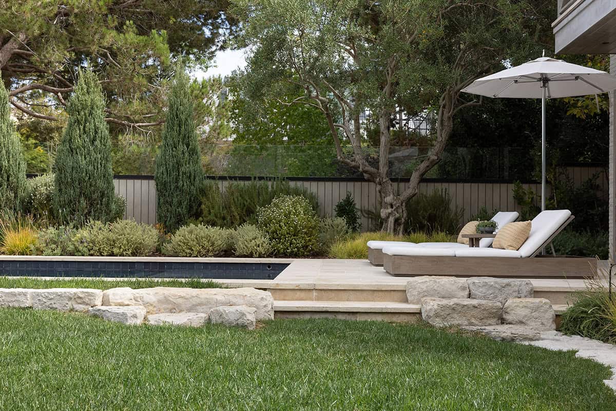 transitiional style home landscaping with a patio and chaise lounges